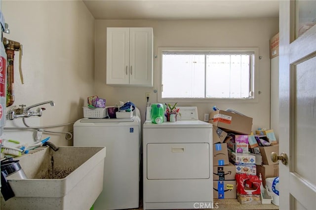 washroom with separate washer and dryer, sink, and cabinets