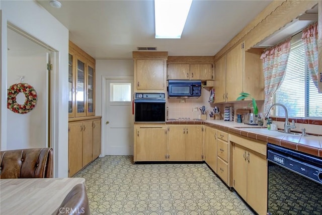 kitchen featuring light brown cabinets, black appliances, sink, tasteful backsplash, and tile counters