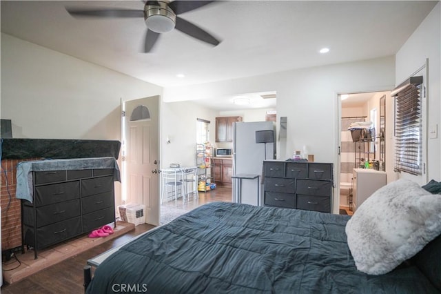 bedroom featuring ceiling fan, ensuite bath, and dark wood-type flooring