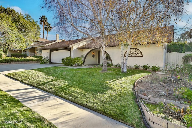 view of front of property featuring a front yard and a garage