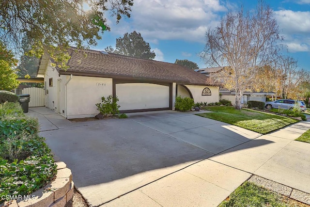 single story home featuring a front lawn and a garage