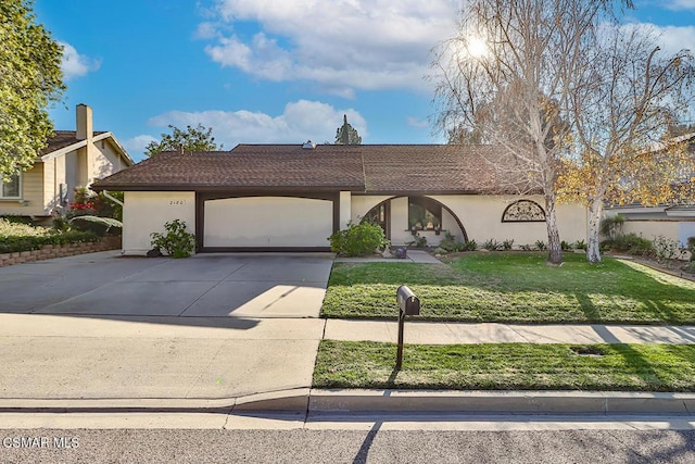 view of front of property featuring a front yard and a garage