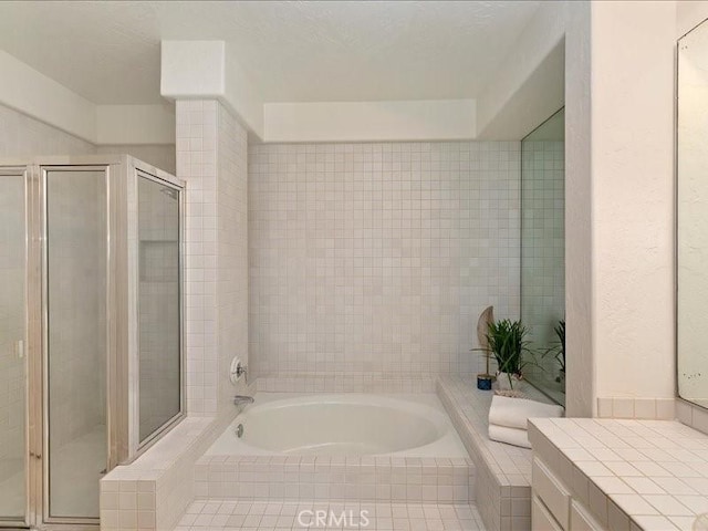 bathroom with a stall shower and a bath