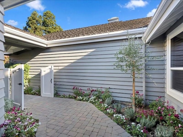 view of property exterior featuring a patio and a chimney