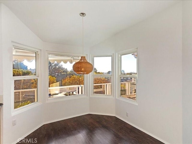 unfurnished dining area with vaulted ceiling and hardwood / wood-style flooring