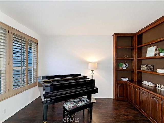 sitting room with baseboards and dark wood finished floors