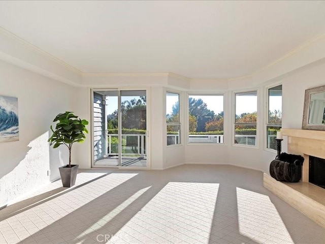 unfurnished sunroom featuring crown molding and carpet
