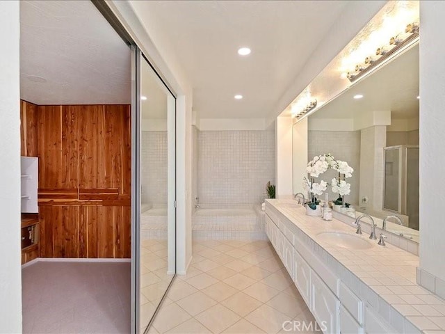 bathroom with an enclosed shower, tile patterned floors, wood walls, and a sink