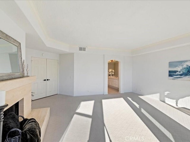 living room featuring light colored carpet, a premium fireplace, and ornamental molding