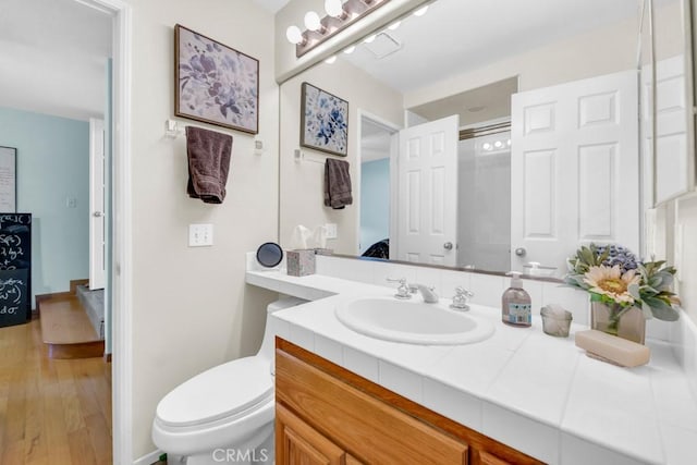 bathroom featuring toilet, hardwood / wood-style floors, and vanity