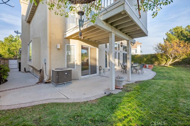 back of property with a lawn, central AC, a balcony, and a patio