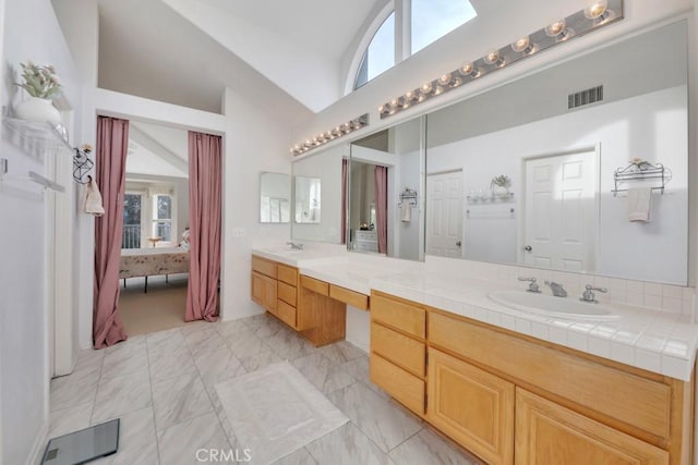 bathroom featuring high vaulted ceiling and vanity