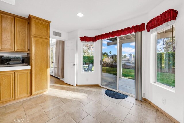 doorway to outside with light tile patterned floors