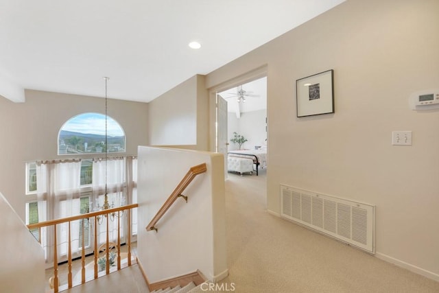 stairway featuring ceiling fan and carpet flooring