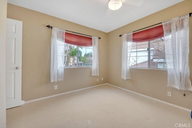 carpeted spare room with ceiling fan