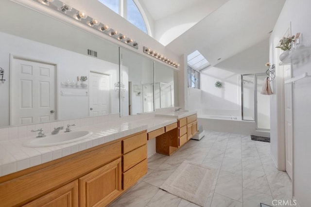 bathroom with vanity, independent shower and bath, and vaulted ceiling