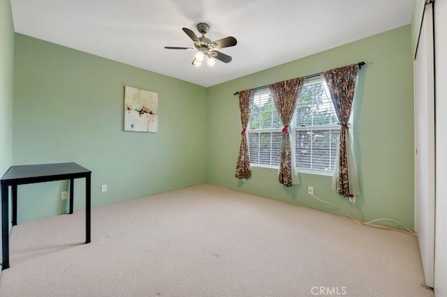 empty room with ceiling fan and carpet