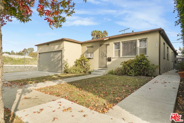 view of front of home with cooling unit, a front yard, and a garage