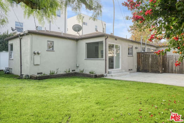 rear view of property with a patio area and a lawn