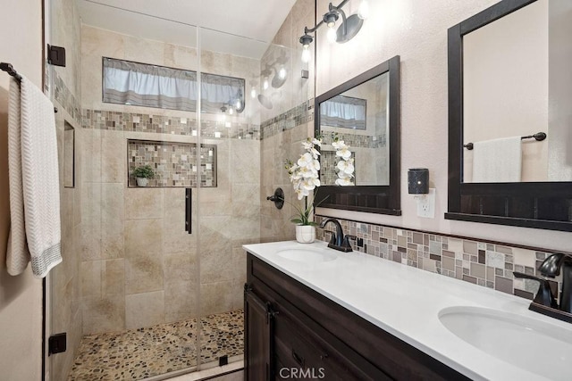 bathroom featuring vanity, tasteful backsplash, and an enclosed shower