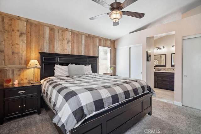 bedroom featuring carpet flooring, ensuite bathroom, ceiling fan, and vaulted ceiling