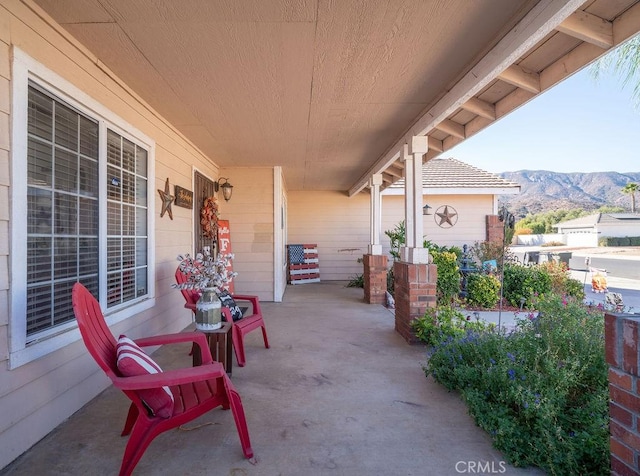 view of patio featuring a mountain view and a porch