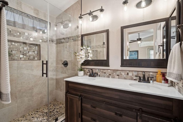 bathroom with backsplash, vanity, vaulted ceiling, a shower with door, and ceiling fan