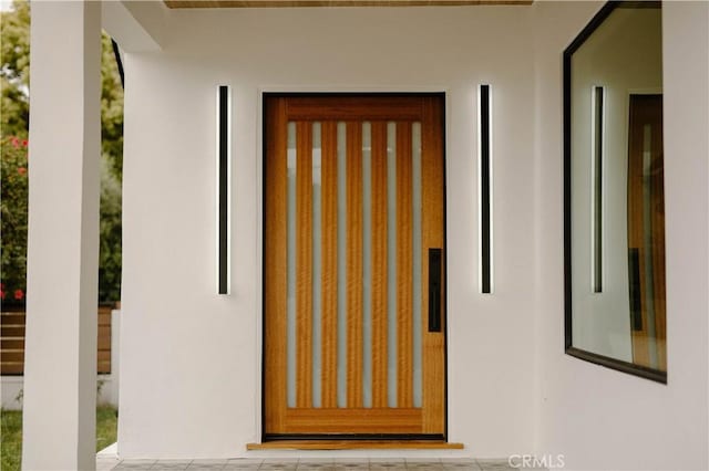 view of exterior entry featuring stucco siding