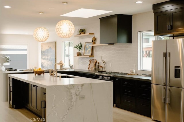 kitchen with open shelves, wall chimney range hood, a sink, decorative backsplash, and stainless steel fridge