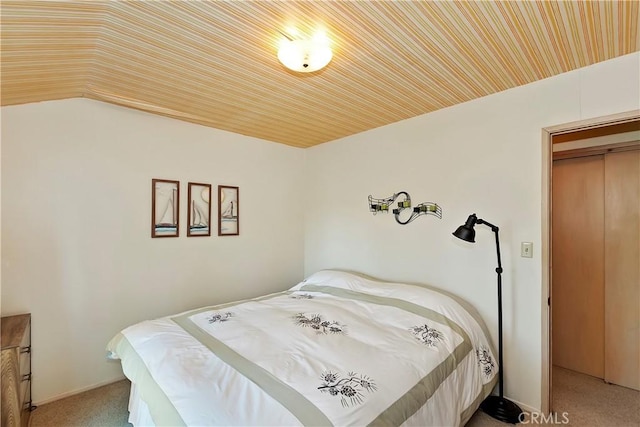 bedroom featuring carpet floors, vaulted ceiling, and a closet