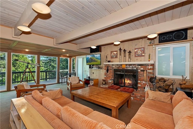 living room with wood walls, a fireplace, carpet floors, and beamed ceiling