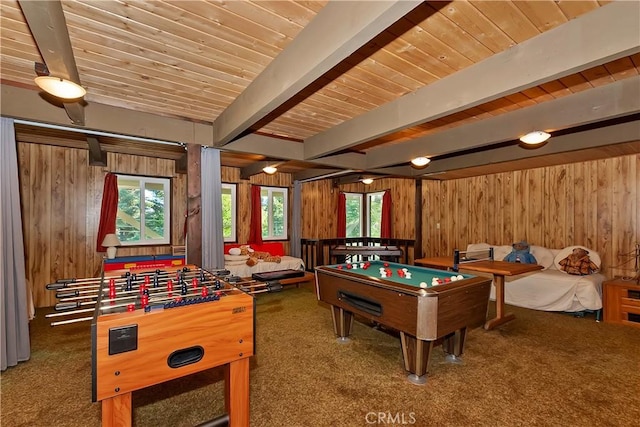 recreation room with carpet flooring, beam ceiling, and wood walls