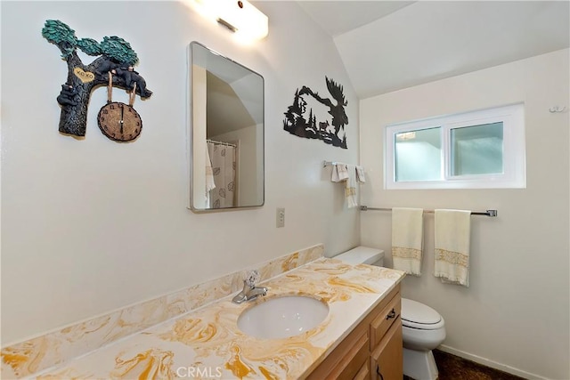 bathroom with vanity, vaulted ceiling, and toilet