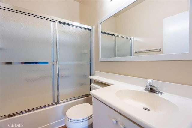 full bathroom featuring vanity, toilet, and combined bath / shower with glass door