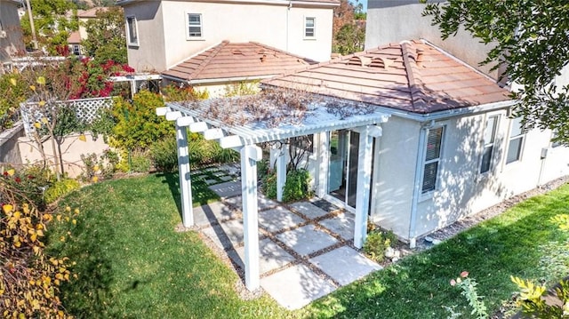 back of property featuring a yard, a pergola, and a patio area