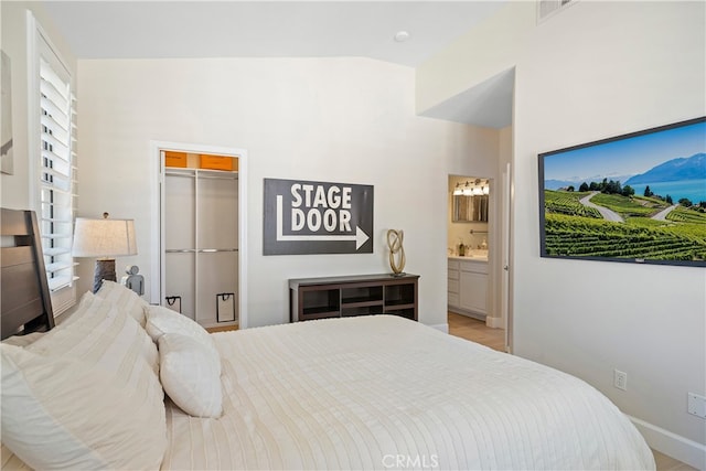 bedroom with ensuite bathroom, a spacious closet, and a closet