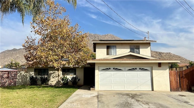 145 Carlota Way, Riverside, CA 92507 - traditional-style home with stucco siding, concrete driveway, a mountain view, roof mounted solar panels, and a garage