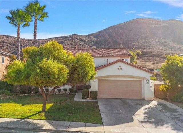 view of front of house featuring a mountain view, a garage, and a front yard