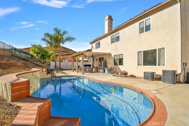 view of swimming pool featuring a patio area, ceiling fan, and central AC