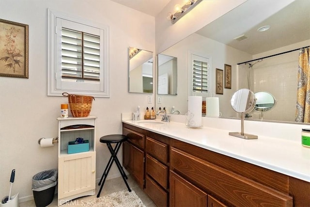 bathroom with walk in shower, vanity, and tile patterned flooring