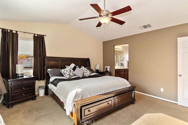 bedroom with vaulted ceiling, ceiling fan, ensuite bathroom, and light colored carpet