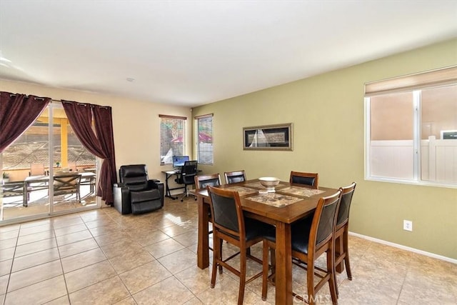 tiled dining room featuring a healthy amount of sunlight