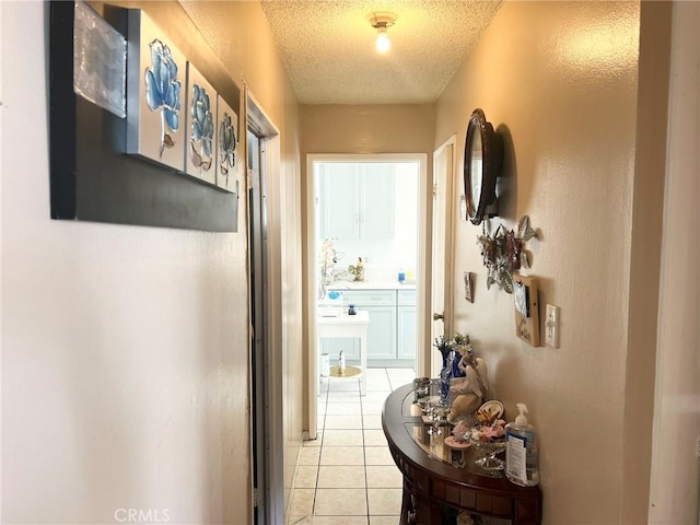 corridor with light tile patterned floors and a textured ceiling