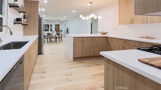 kitchen featuring pendant lighting, dishwasher, an inviting chandelier, sink, and light wood-type flooring