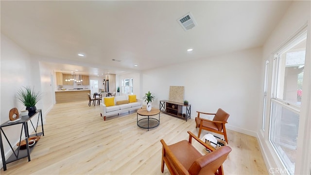 living room with a chandelier and light hardwood / wood-style flooring