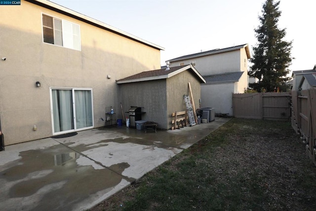 rear view of property featuring a patio and central AC