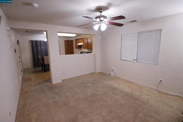 spare room with light colored carpet and ceiling fan