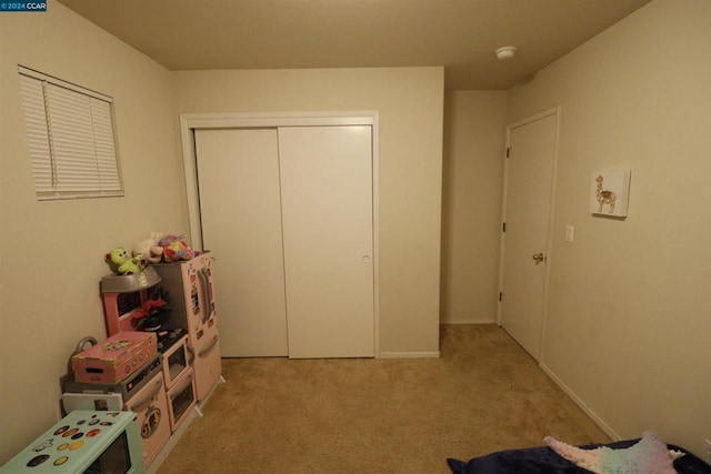 unfurnished bedroom featuring light carpet and a closet