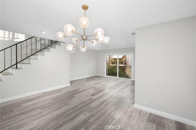 unfurnished dining area featuring light hardwood / wood-style flooring and a notable chandelier