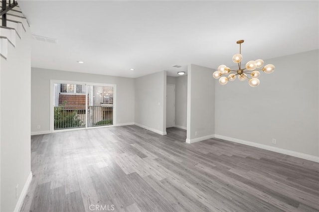 unfurnished living room featuring hardwood / wood-style floors and a notable chandelier